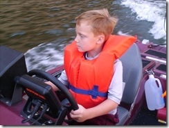 My son learning to operate a boat.